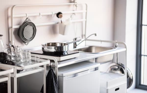 Cocina básica con olla en la cocina y muebles con borde blanco.