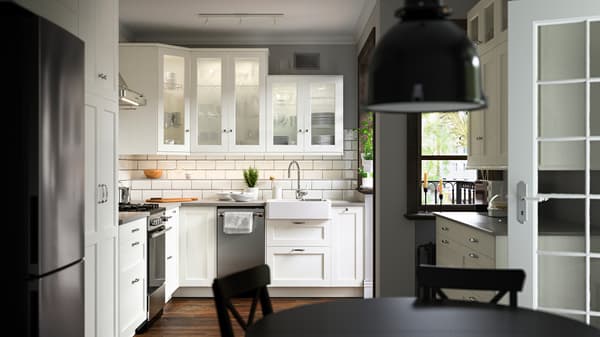Cocina con frentes blancos ENKÖPING, una parrilla CIRKULERA de acero inoxidable, un fregadero HAVSEN y una lámpara de techo SVARTNORA.