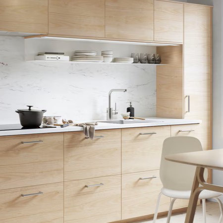 Cocina luminosa escandinava con frentes en fresno y encimera blanca