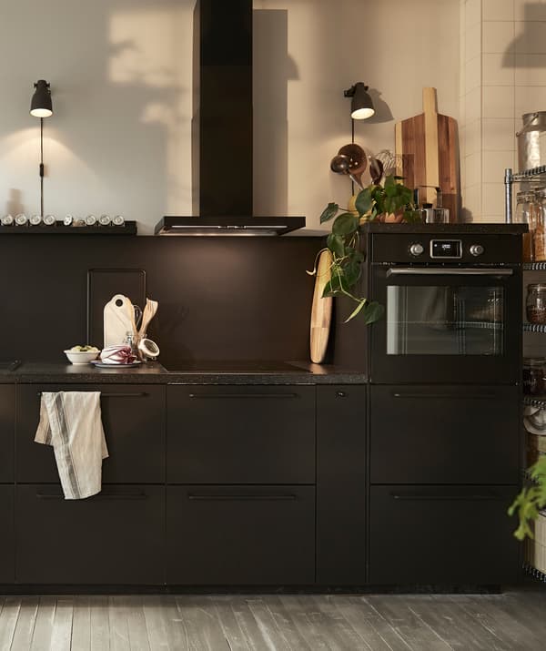 Cociña negra con extractor, forno integrado e mesados escuros