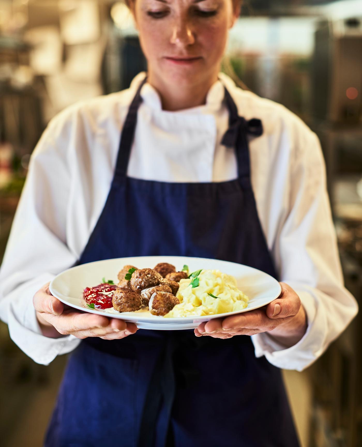 cocinera de ikea sujetando un plato de albondigas suecas