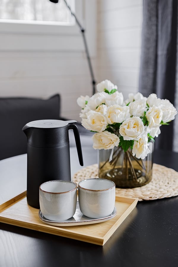 Coffee set with white flowers on black dining table