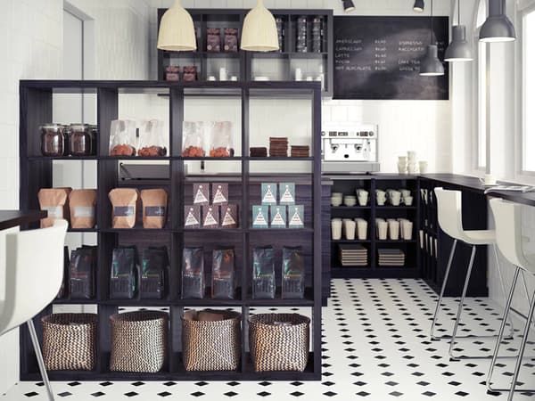 Coffeeshop mit dunklen KALLAX Regalen, KALLAX Raumteiler & verchromten BERNHARD Barhocker in weiß