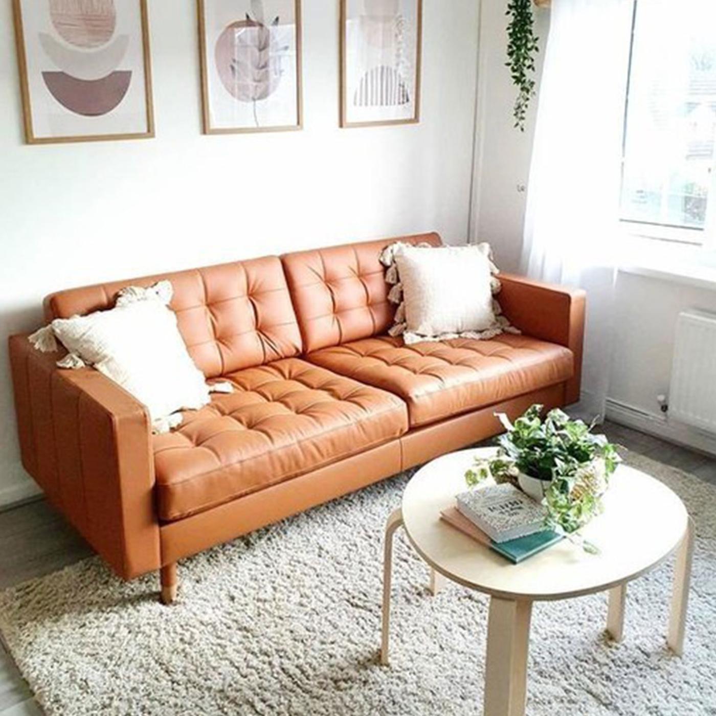 Cognacfärgad skinnsoffa i ljust rum. 