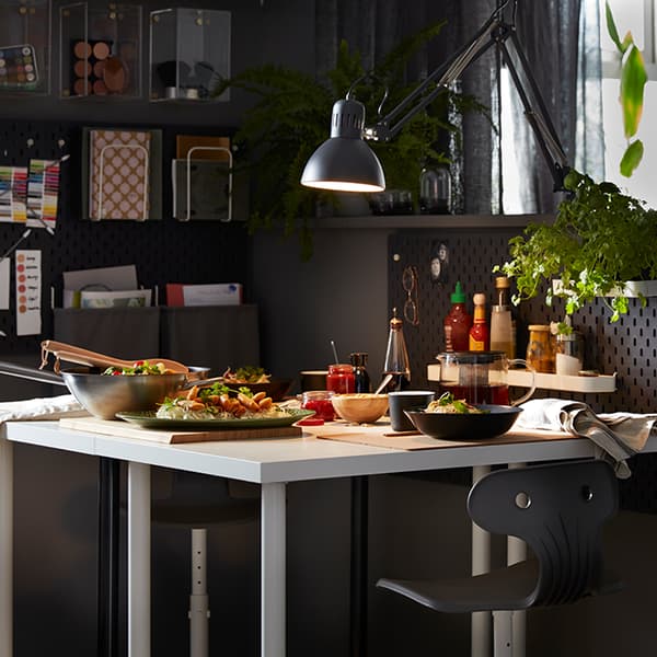 Coin bureau reconverti en coin repas, avec une table IKEA LINNMON blanche et des fauteuils pivotants MOLTE gris foncé.