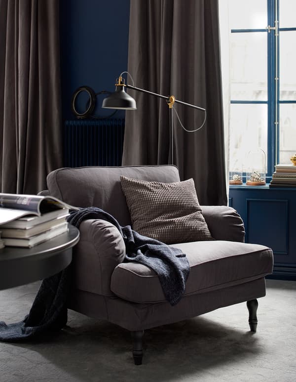 Coin lecture avec fauteuil, lampadaire et table.