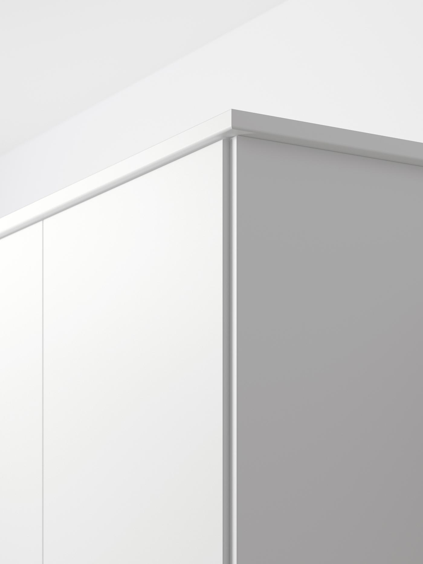 Coin supérieur d’une armoire blanche avec une porte au fini blanc mat.