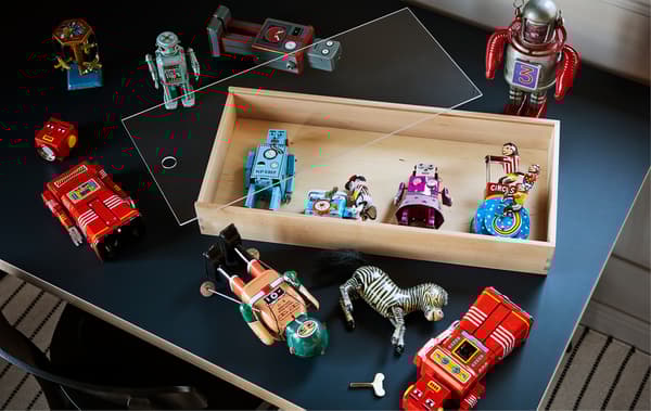 Col·lecció de joguines robot antigues en una taula amb una minivitrina SAMMANHANG.
