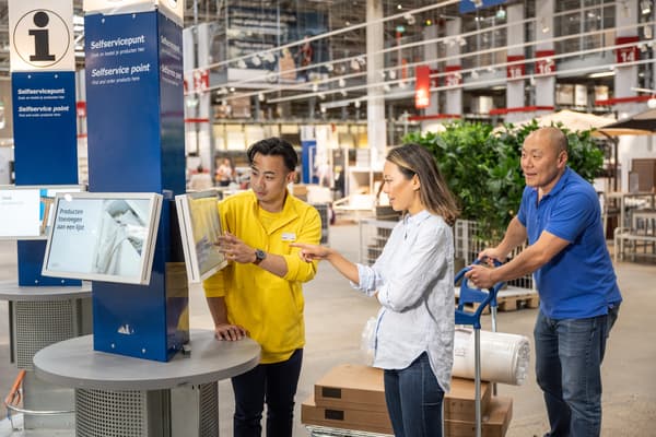 Colaborador IKEA conversando con dos clientes.