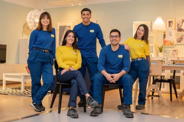 Colaboradores riendo y abrazados usando poleras amarillas y azules, los colores de IKEA.