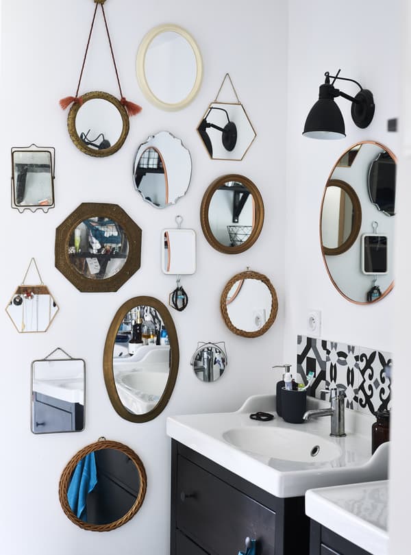 Collection de miroirs au mur de la salle de bain.
