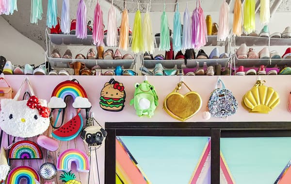 Collection de sacs et de chaussures colorés, sur un mur.