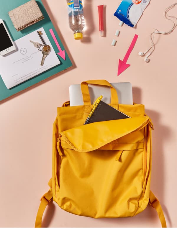 College essentials like a laptop being packed into a backpack.