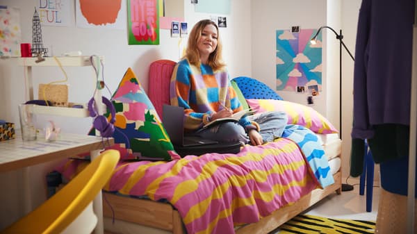 College student sitting on their bed in a dorm