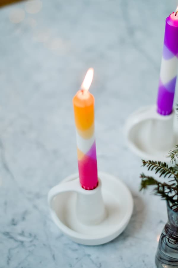 Colourful candles in a white candle holder