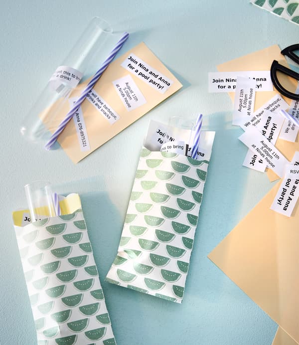 Colourful envelopes each hold glass tubes, paper straws and a small note with party information.