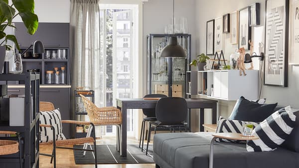 Combinación de comedor e sala cun estilo coordinado, con mobles de ratán e tons marróns, grises e antracita.