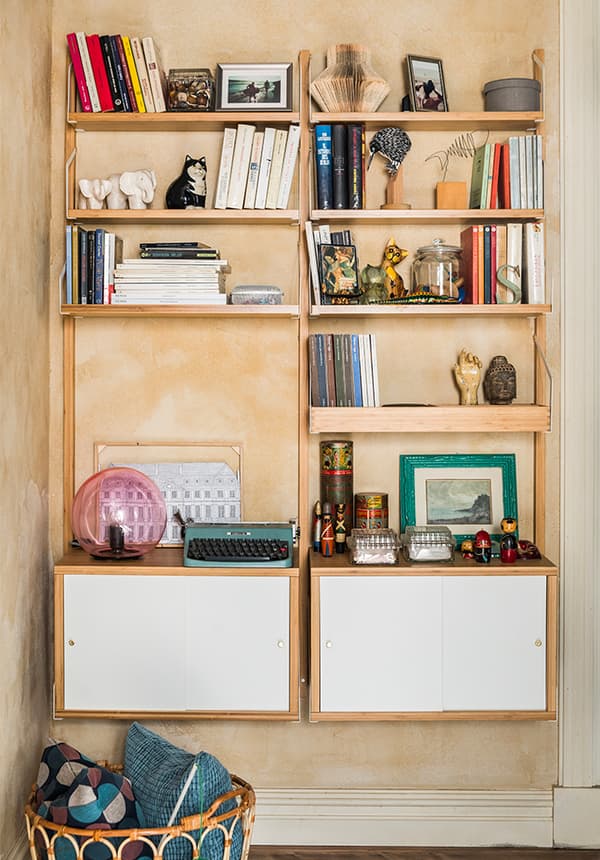 Combinazione a parete di mobili EKET. Sui ripiani ci sono diversi oggetti tra cui una lampada, una maccina da scrivere, cornici, libri e diverse decorazioni.