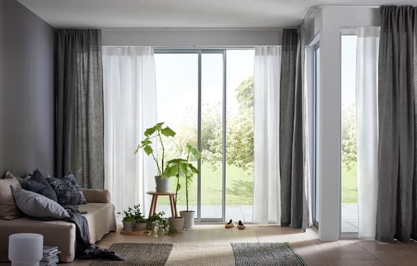 Combinazione con due strati di tende sottili bianche e beige che lasciano filtrare la luce del sole e uno strato di tende spesse color grigio scuro che salvaguardano la privacy - IKEA