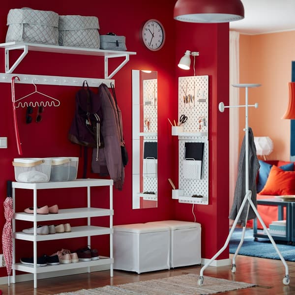 Combine l’étagère à chaussures empilable MACKAPÄR avec une étagère murale, un repose-pieds et un panneau perforé blancs et crée un rangement pour les chaussures, les manteaux et les petits objets dans une entrée petite et ouverte. Le mur rouge crée une impression chaleureuse dès que l’on pénètre dan