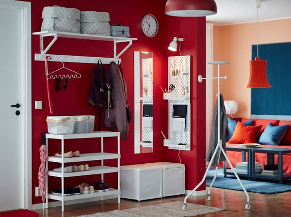 Combine l’étagère à chaussures empilable MACKAPÄR avec une étagère murale, un repose-pieds et un panneau perforé blancs et crée un rangement pour les chaussures, les manteaux et les petits objets dans une entrée petite et ouverte. Le mur rouge crée une impression chaleureuse dès que l’on pénètre dan