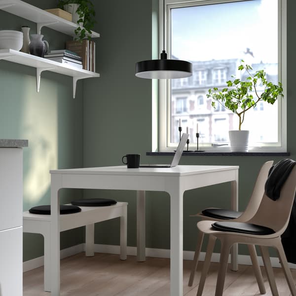 COMEDOR VERDE CON MUEBLES BLANCOS Y COJINES NEGROS EN LAS SILLAS