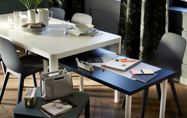 Comme de grandes tables gigognes: une table pour les devoirs coulisse sous une table à manger où sont disposés des couverts.