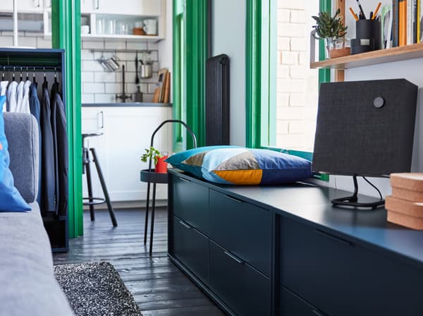 Commode IKEA NORDMELA bleue utilisée en guise de banc, avec coussin de couleur et haut-parleur ENEBY.