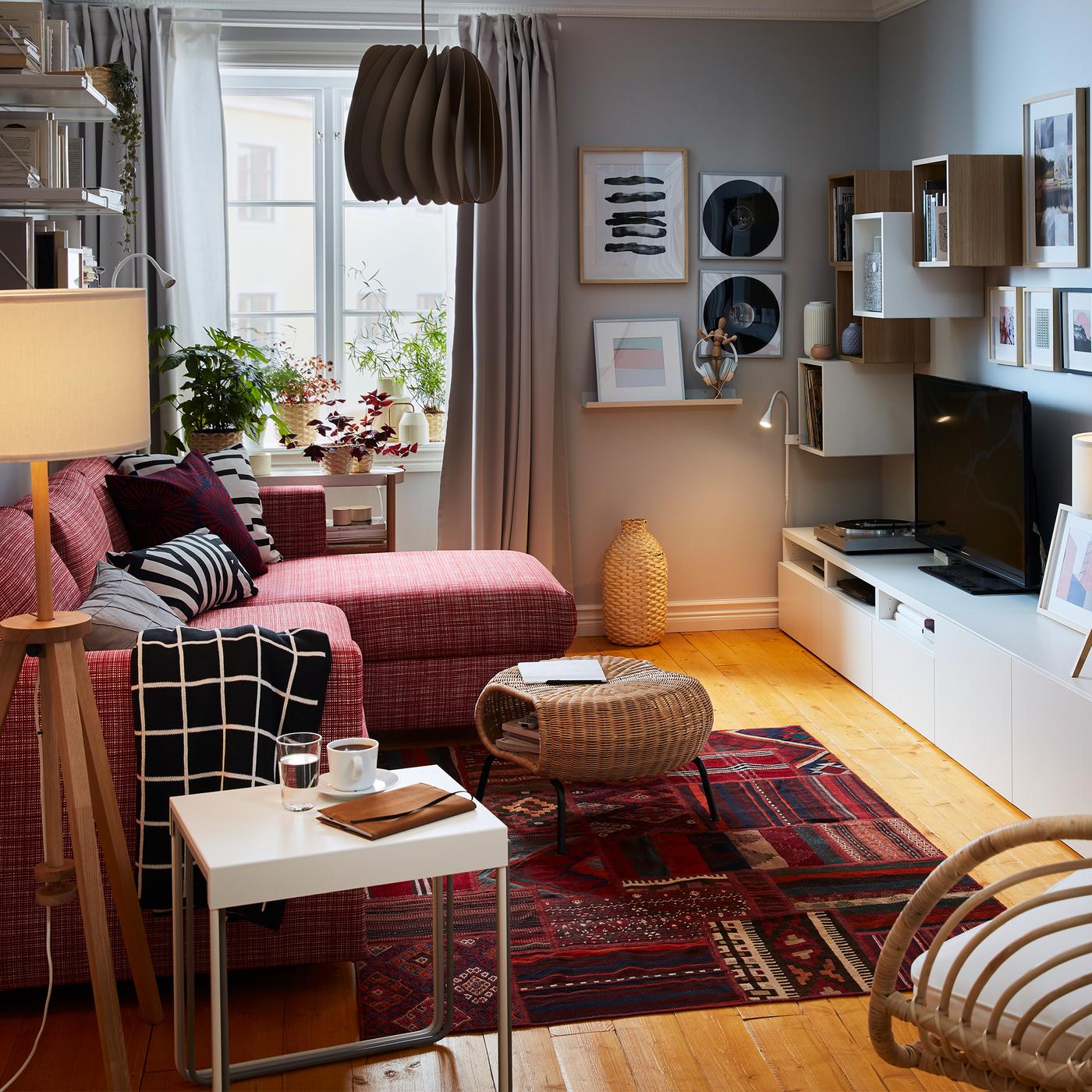 Compact living room with a sofa-bed with chaise longue on one side; sideboard, storage, TV, stereo and art on the other.