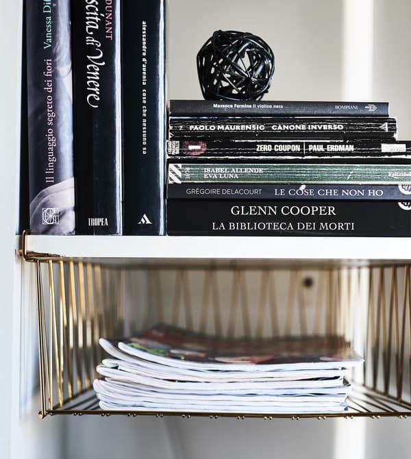 Compartiment KALLAX avec corbeille en fil et livres dedans.