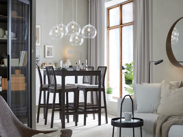 Con il tavolo bar per 4 persone grigio scuro e le sedie bar della serie EKEDALEN, il comodo divano letto HOLMSUND e il paralume in vetro per lampada a sospensione JAKOBSBYN puoi creare un ambiente classico dove soggiorno e zona pranzo convivono in armonia - IKEA