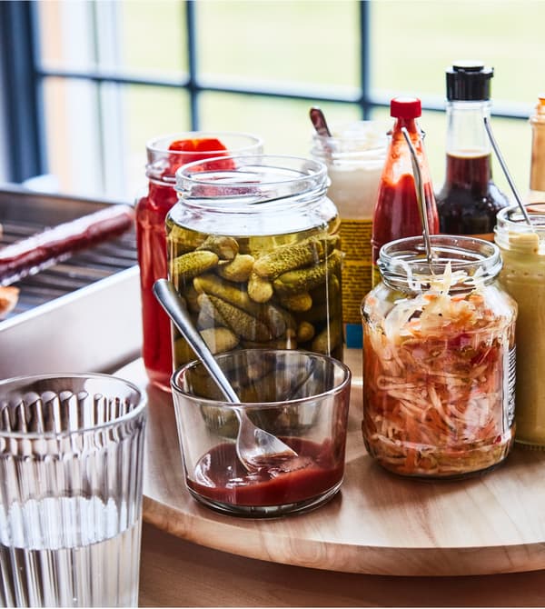 Condiments de toutes sortes posés sur un plateau tournant, sur une table.