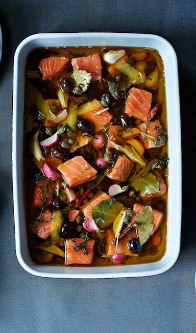 Confit de salmó amb fonoll servit en una safata blanca per a forn, vist des de dalt.