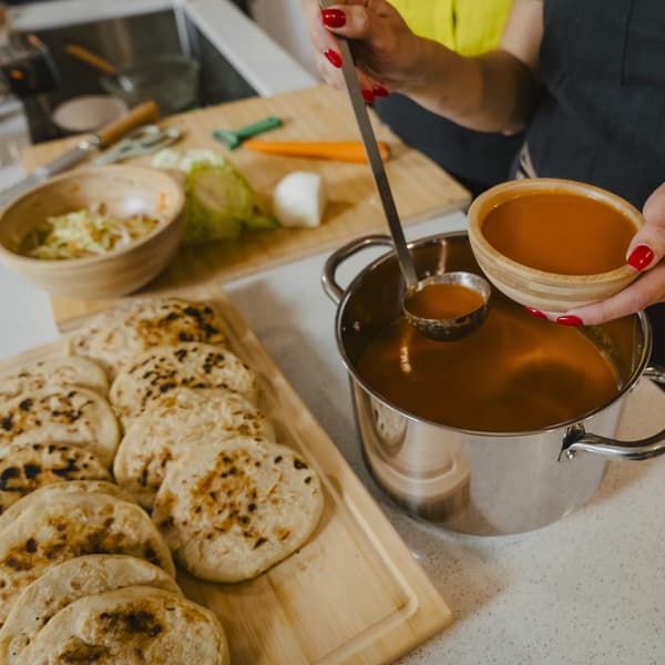 Consume soup being scooped out of a pot.