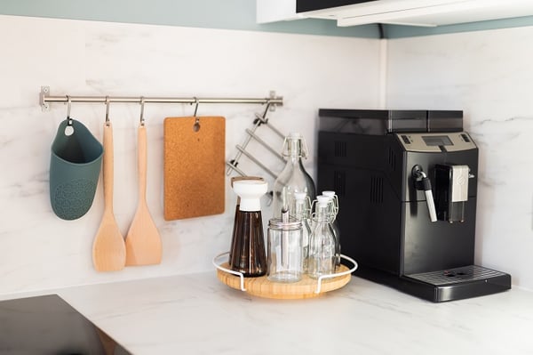Contemporary L-shaped kitchen with white cabinets, built-in appliances and wooden flooring
