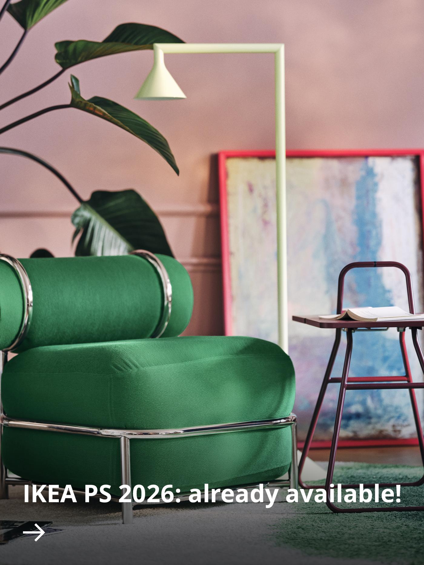 Contemporary lounge corner with a green IKEA PS 2026 easy chair, a dark red side table and framed artwork.