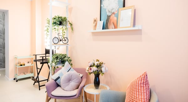 Contemporary open office layout with green accent wall, collaborative desks, and stylish lighting