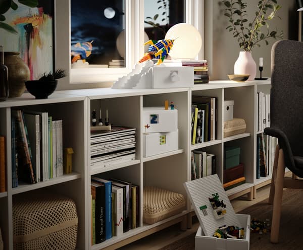 Contenitore BYGGLEK bianco su uno scaffale KALLAX. Su un lato del contenitore è stato costruito un razzo con i mattoncini LEGO della collezione BYGGLEK.