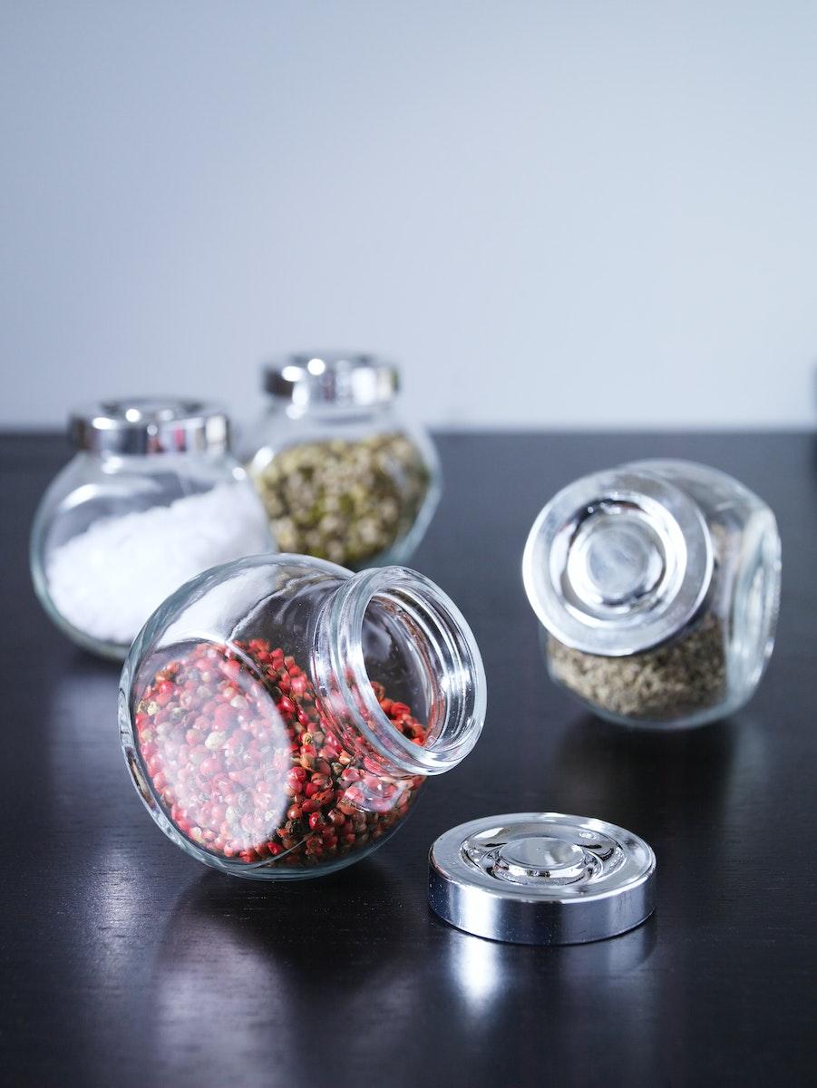 Contenitori in vetro RAJTAN con varie spezie colorate all'interno.