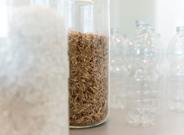 Contenitori per legno riciclato e bottiglie in plastica riciclabile.