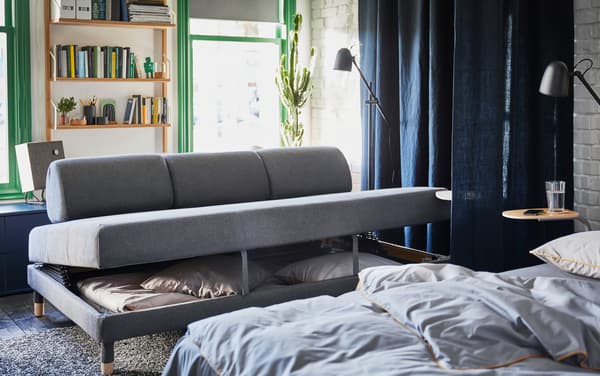 Convertible IKEA FLOTTEBO gris foncé avec trois coussins pour le dos, en position ouverte.