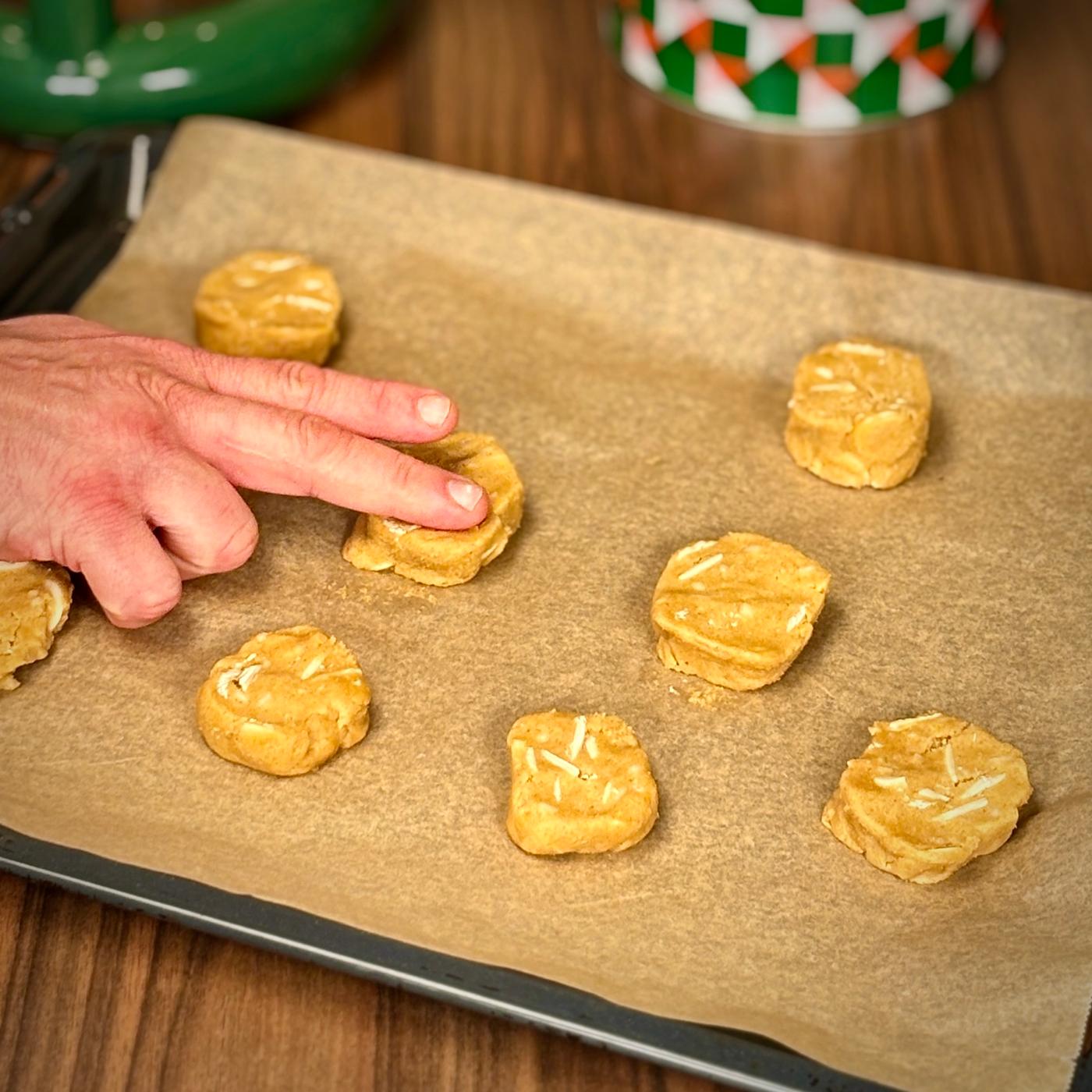 Cookiedej på en bageplade. Dejen får et lille tryk.