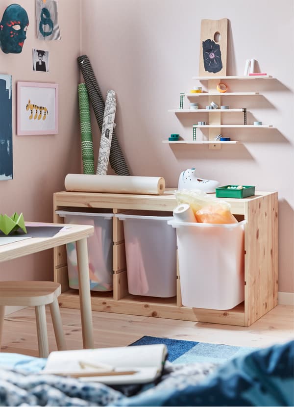 Corpul de depozitare TROFAST, din lemn de pin, de la IKEA, cu trei cutii adânci din plastic, în care se află articole de papetărie și accesorii pentru activitatea creativă. 