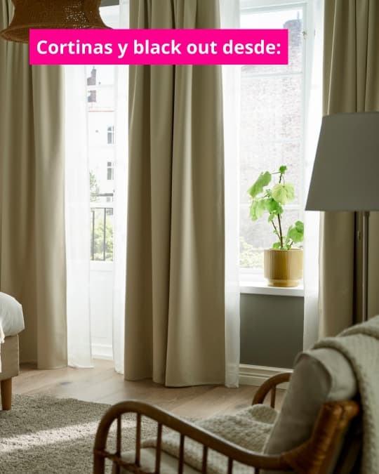 Cortinas largas beige y visillos claros frente a una ventana luminosa en una sala decorada con plantas y sillón. Texto en imagen dice: “Cortinas y black out desde:”.