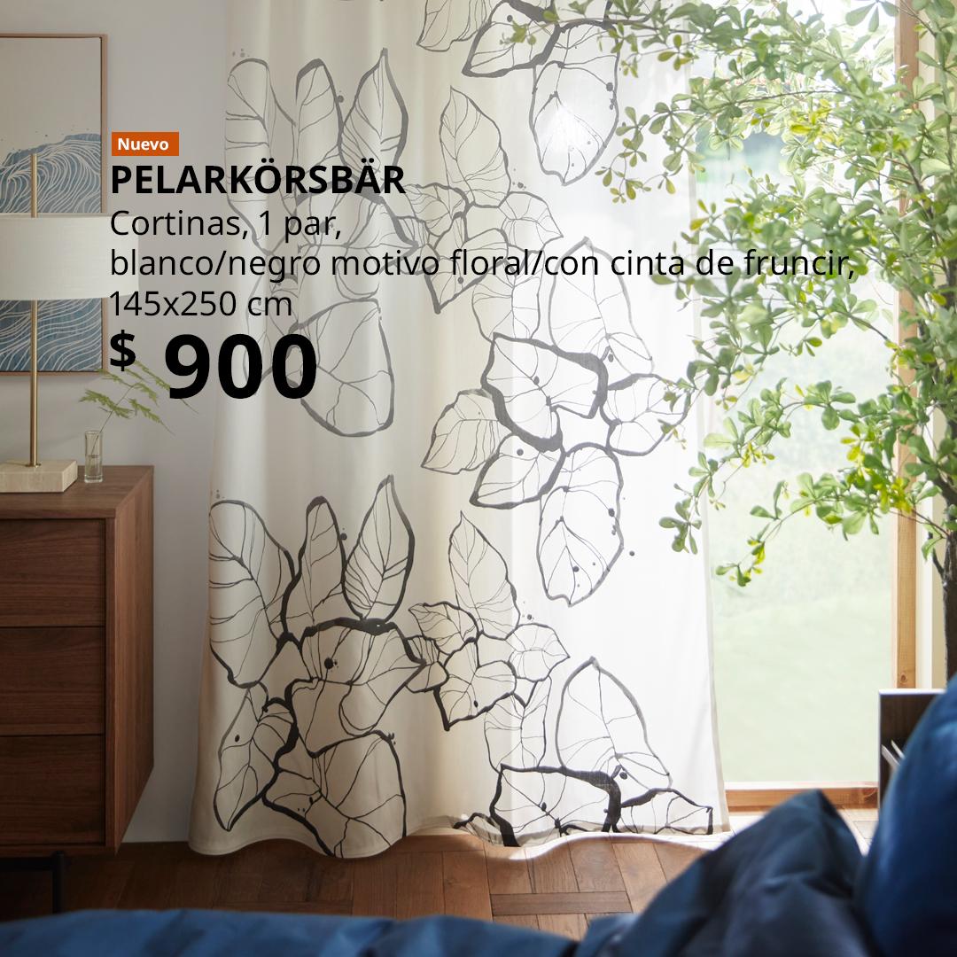 Cortinas PELARKÖRSBÄR blancas con motivo floral negro en una recámara, junto a una ventana.