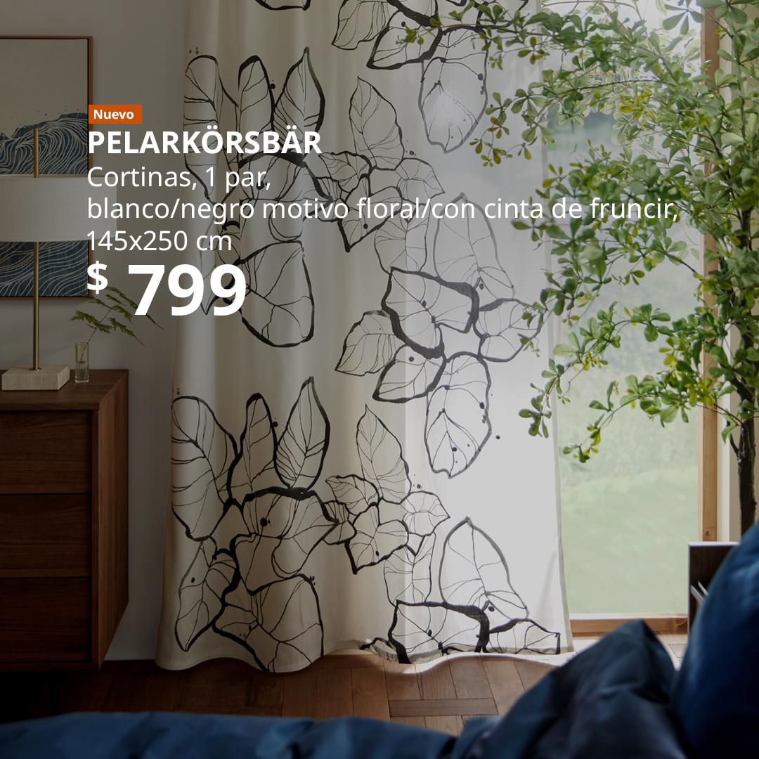 Cortinas PELARKÖRSBÄR blancas con motivo floral negro en una recámara, junto a una ventana.