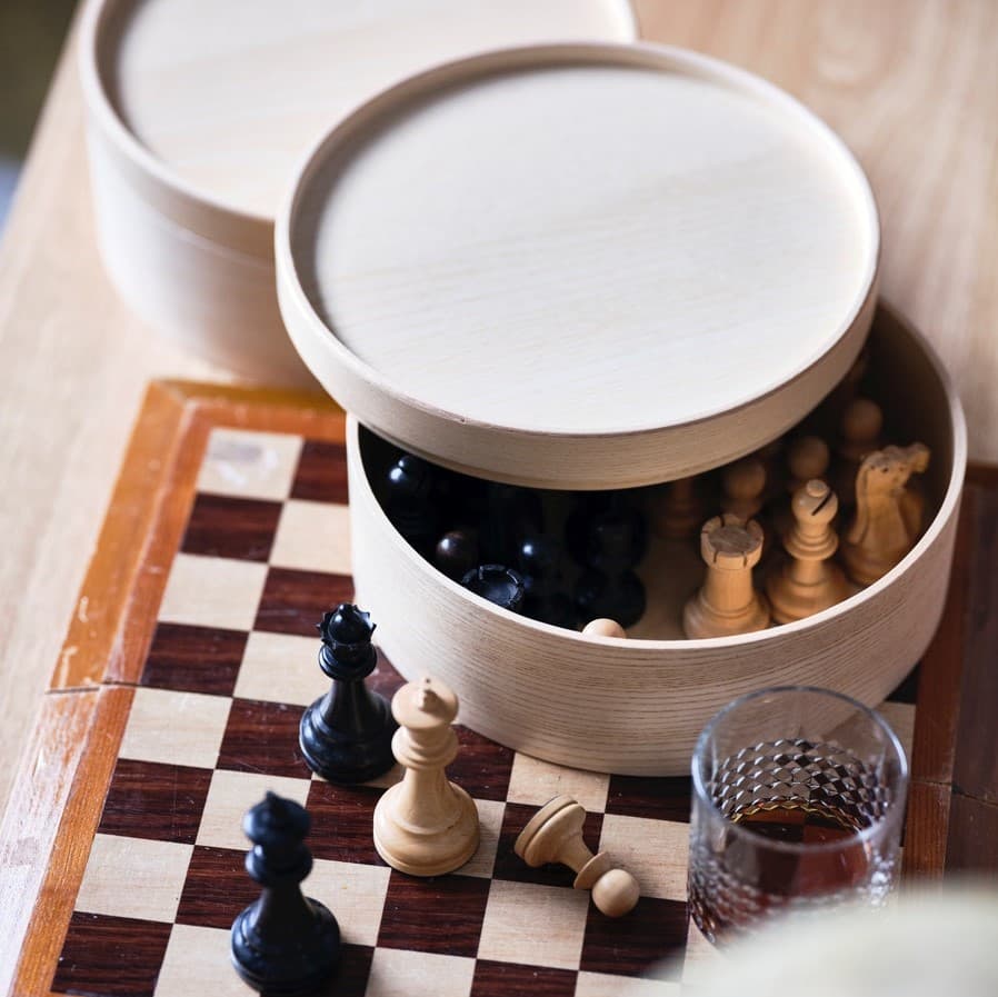 Cotton tea towels are neatly folded and stacked in a wooden bowl.