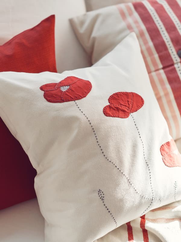 Coussin habillé d’une housse SILOMAL, posé contre un autre coussin habillé d’une housse VEDMAL.