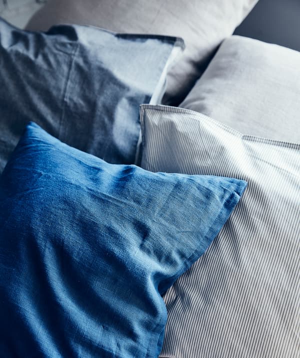 Coussins en nuances de bleu et canapé gris.