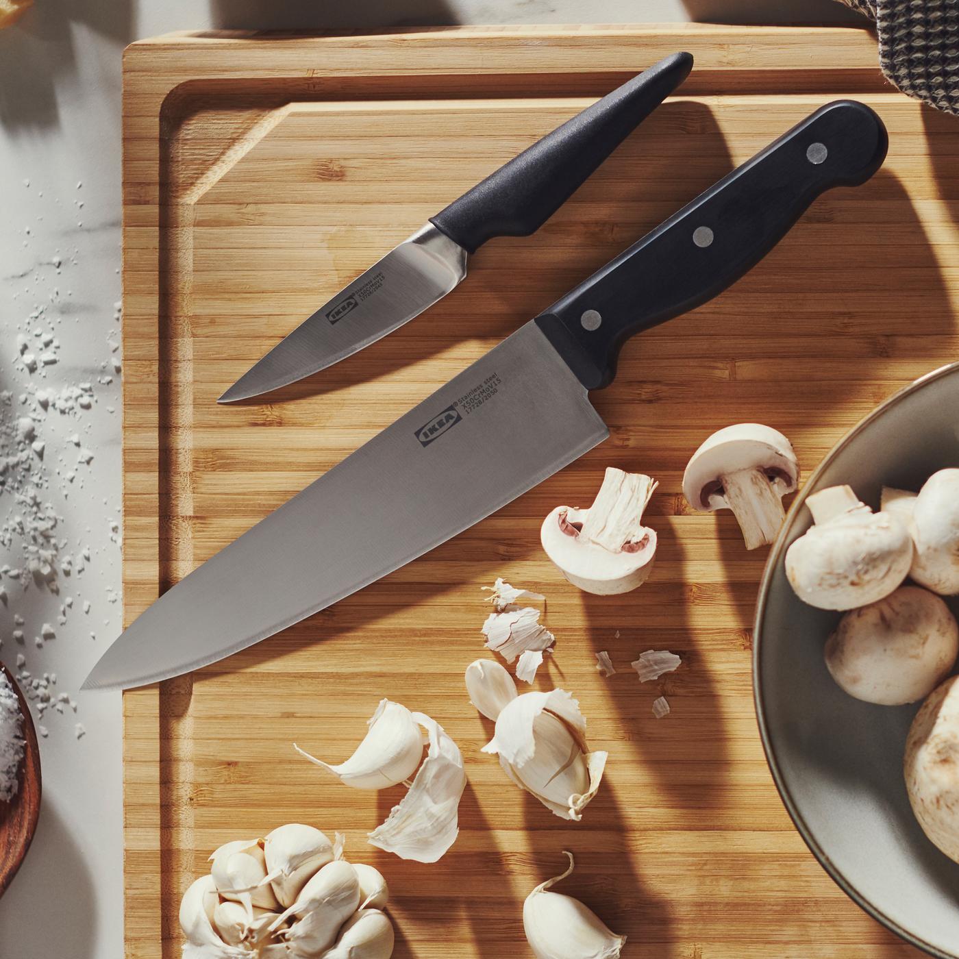Couteau de cuisine VARDAGEN et couteau à éplucher VÖRDA sur un billot APTITLIG en bambou, à côté de quelques champignons.